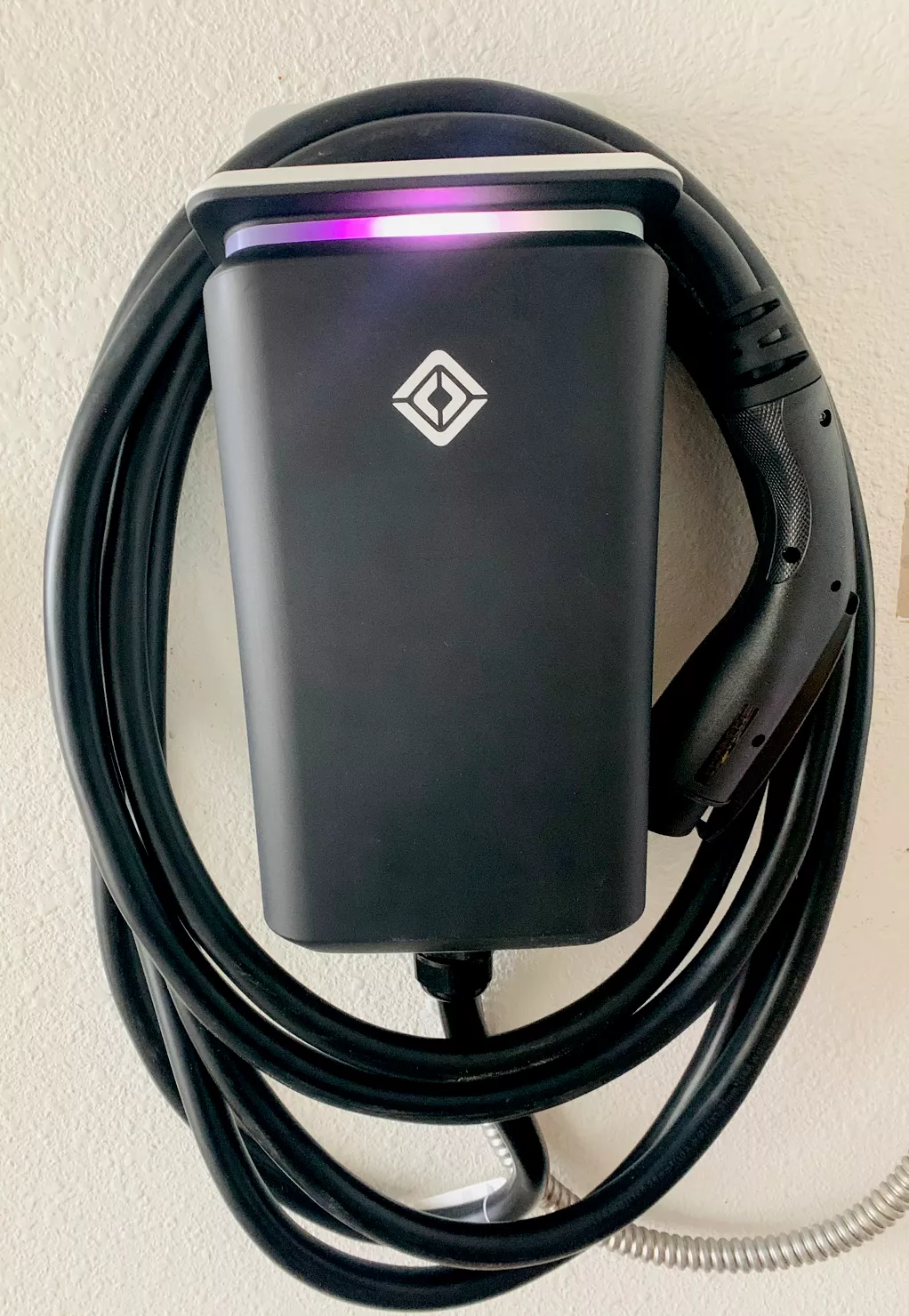 Wall-mounted Level 2 EV charger with neatly coiled cable
